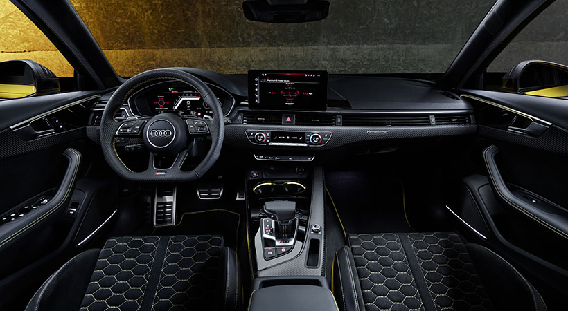 El interior destaca por una placa numerada en la consola central, costuras amarillas y emblemas a juego. Foto: Audi